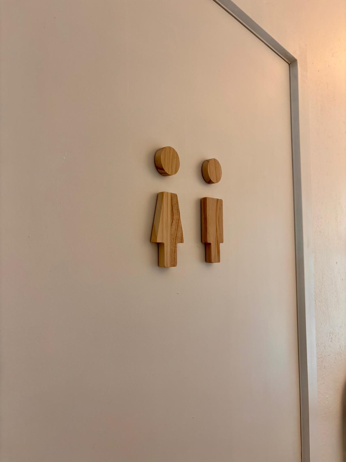 Deur met houten toiletpictogrammen