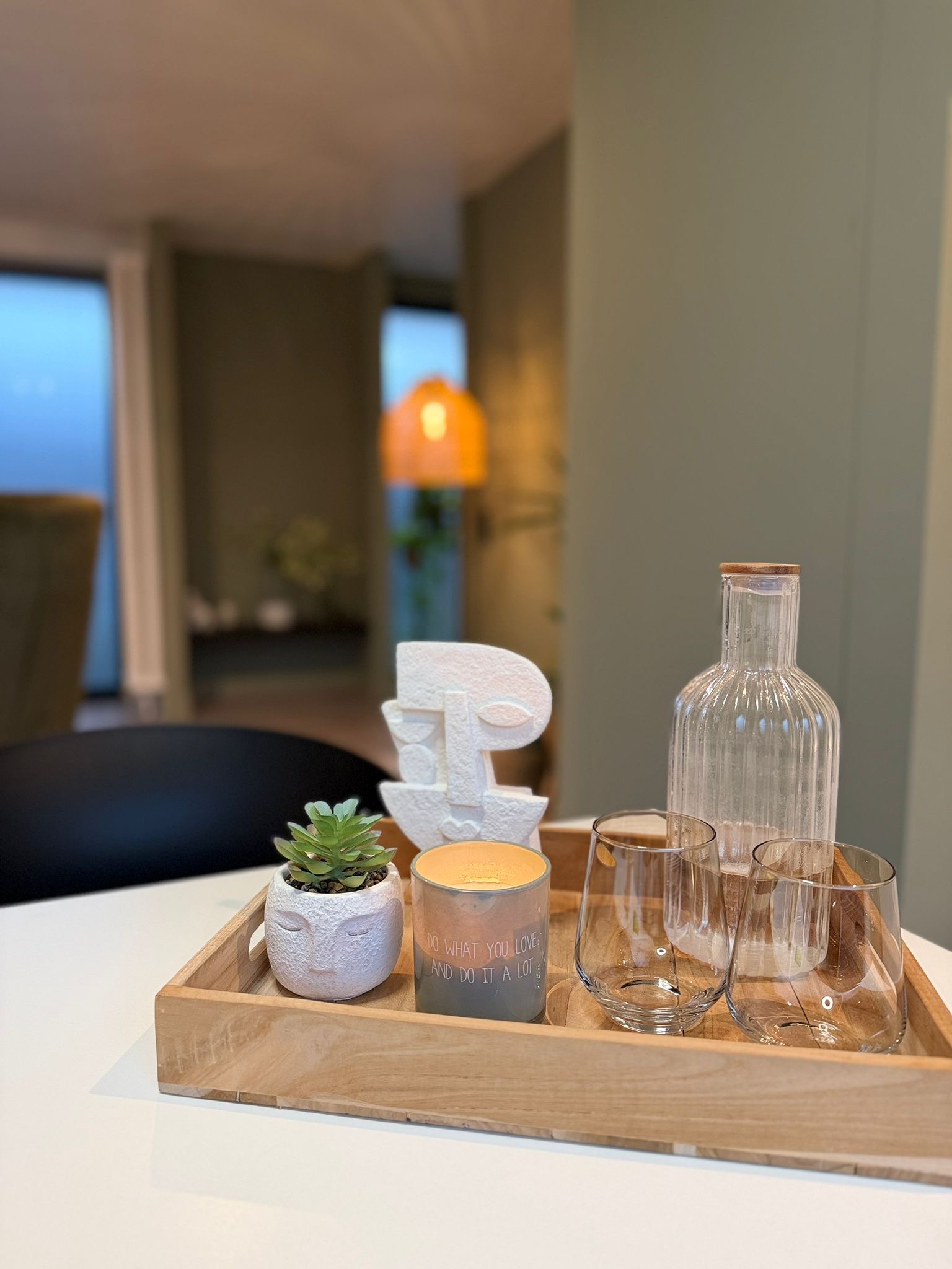Detail met waterkaraf, kaars, plant en warm licht